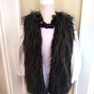 Woman's vest size Medium with big black chunky necklace.
